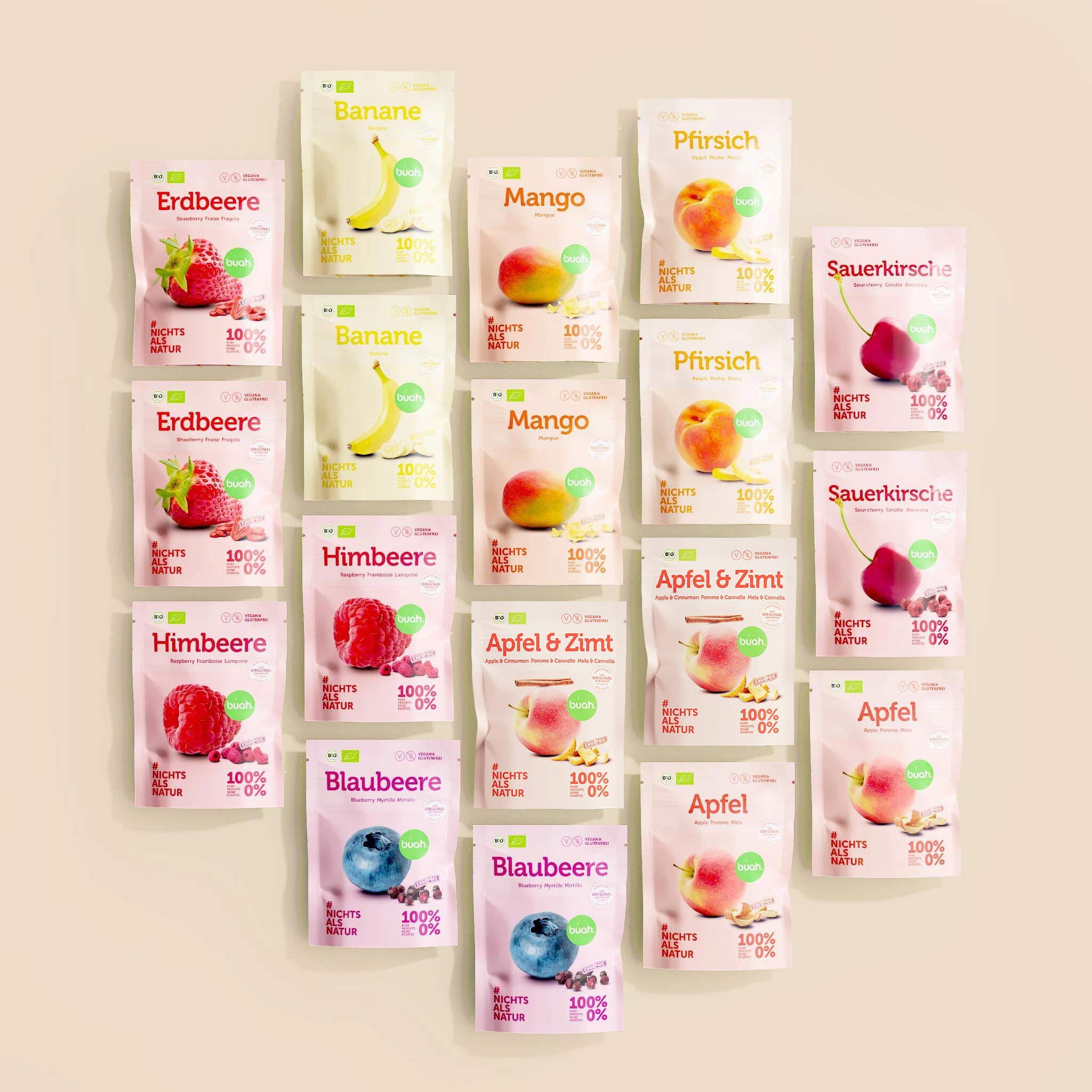 Set aus diversen buah Snackpack in verschiedenen Sorten, Erdbeere, Banane, Mango, Pfirsich, Sauerkirsche, Himbeere, Blaubeere, Apfel & Zimt und Apfel - Snackpacks liegen nebeneinander aus Vogelperspektive, Hintergrund in beige.