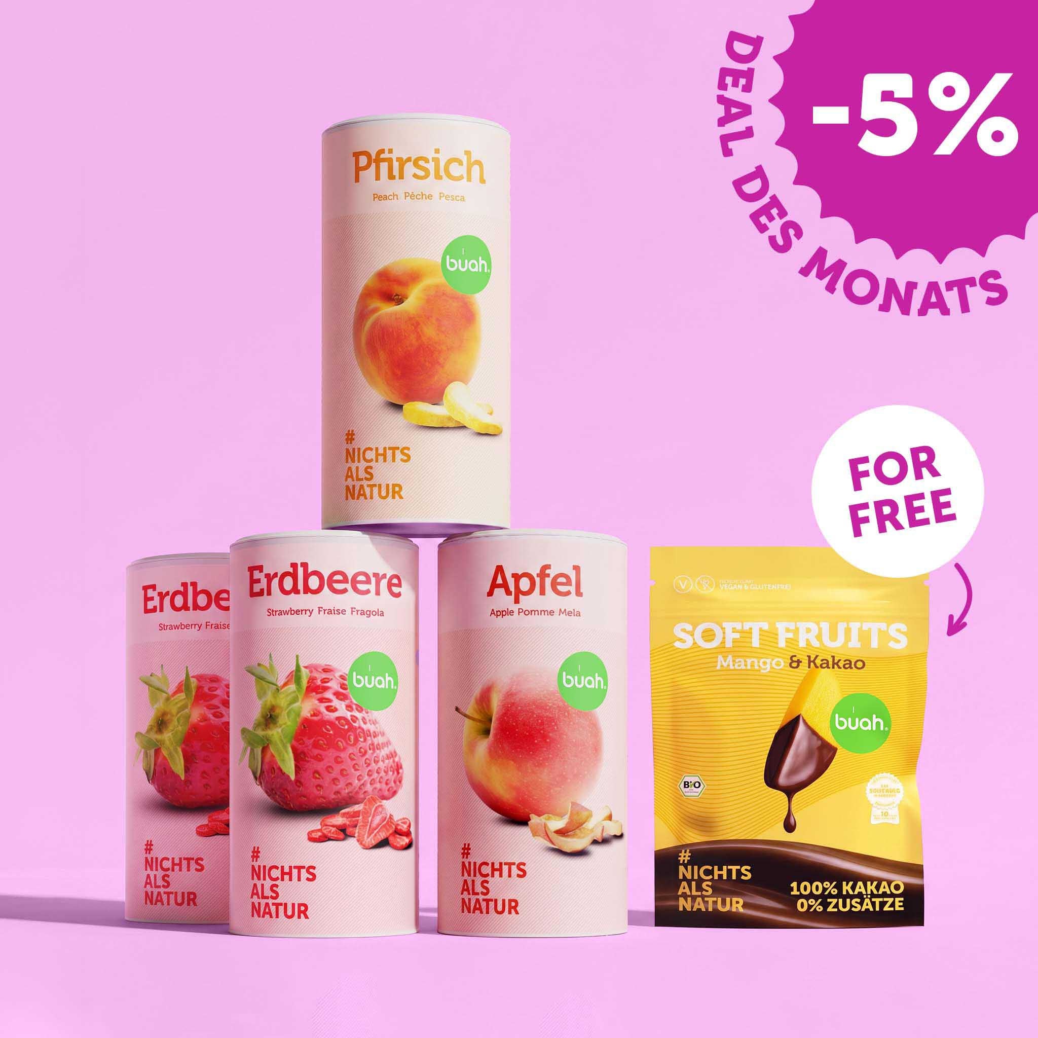 Eine Pyramide aus drei großen Dosen buah gefriergetrocknete Früchte (Pfirsich steht auf Erdbeere und Apfel). Rechts daneben steht ein Beutel buah Soft Fruits Mango & Kakao mit einem „FOR FREE“-Hinweis. Oben rechts ein Badge: „-5% DEAL DES MONATS.