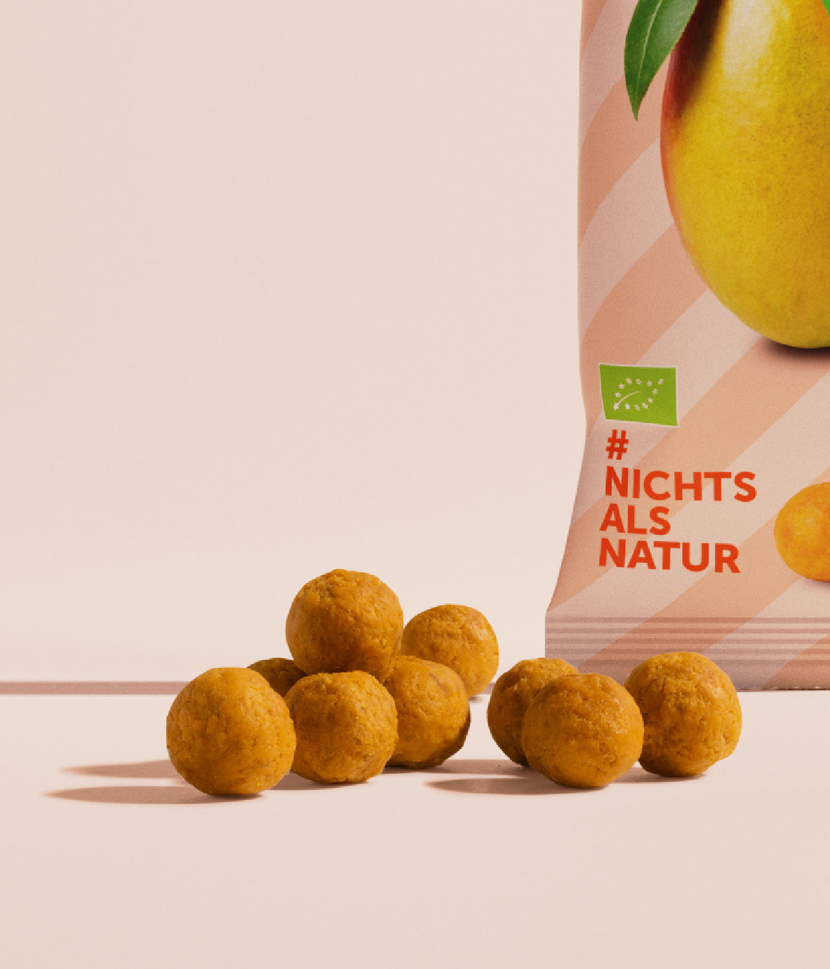 buah Mango Kaubonbons in kleinen orangenen Kugeln neben einer Packung Kaubonbons