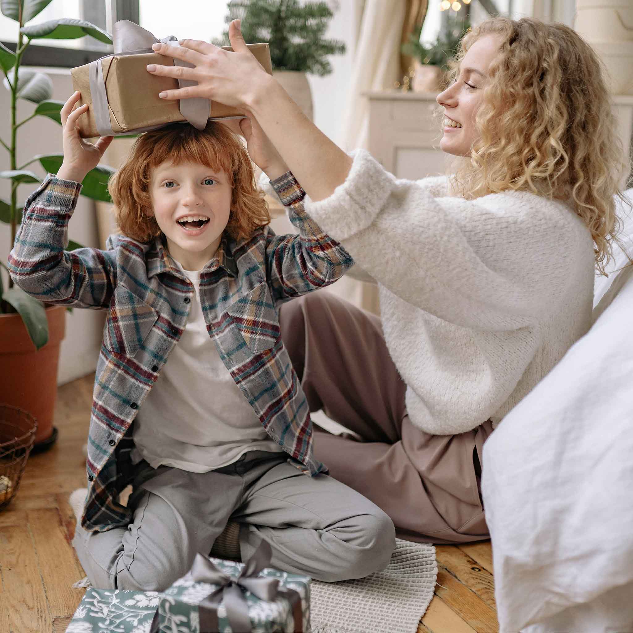 Mama und Sohn packen Weihnachtsgeschenke aus und freuen sich auf Weihnachten 