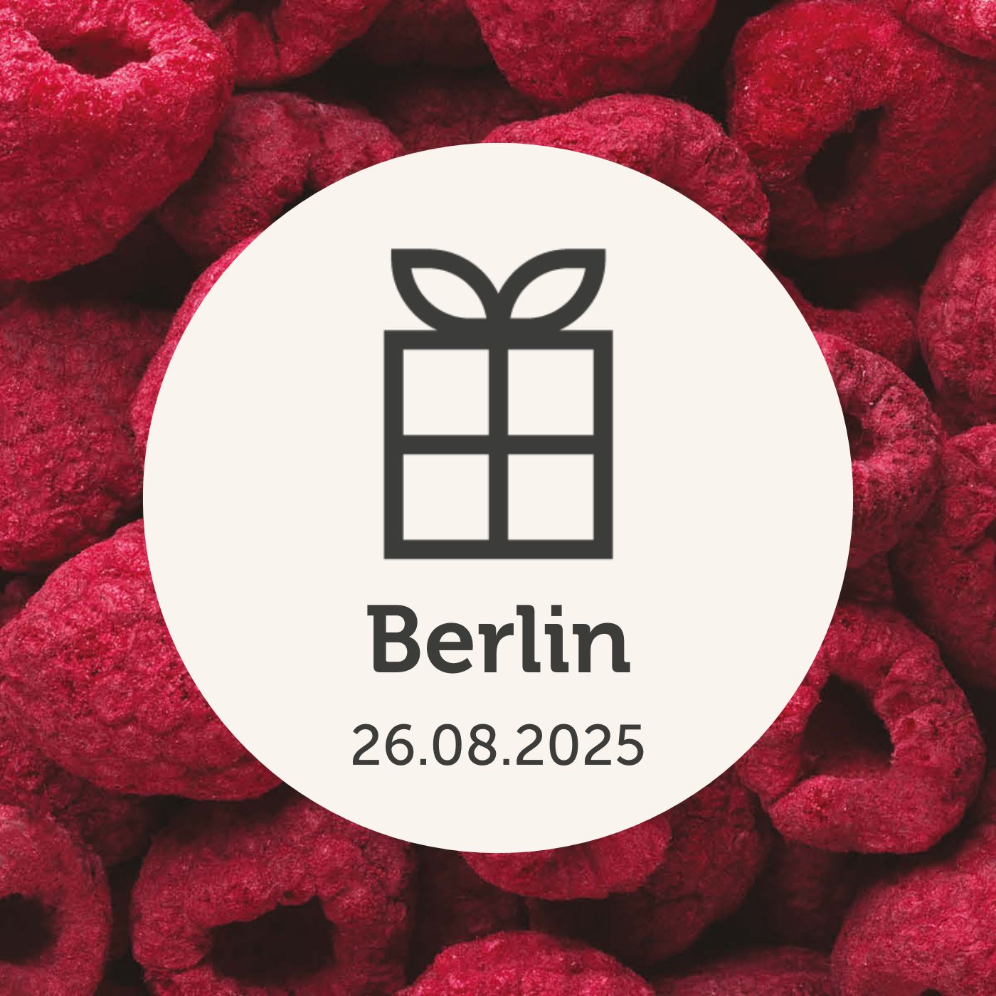 Hintergrund aus buah gefriergetrockneter Himbeere mit Geschenk Logo und Berlin Schriftzug