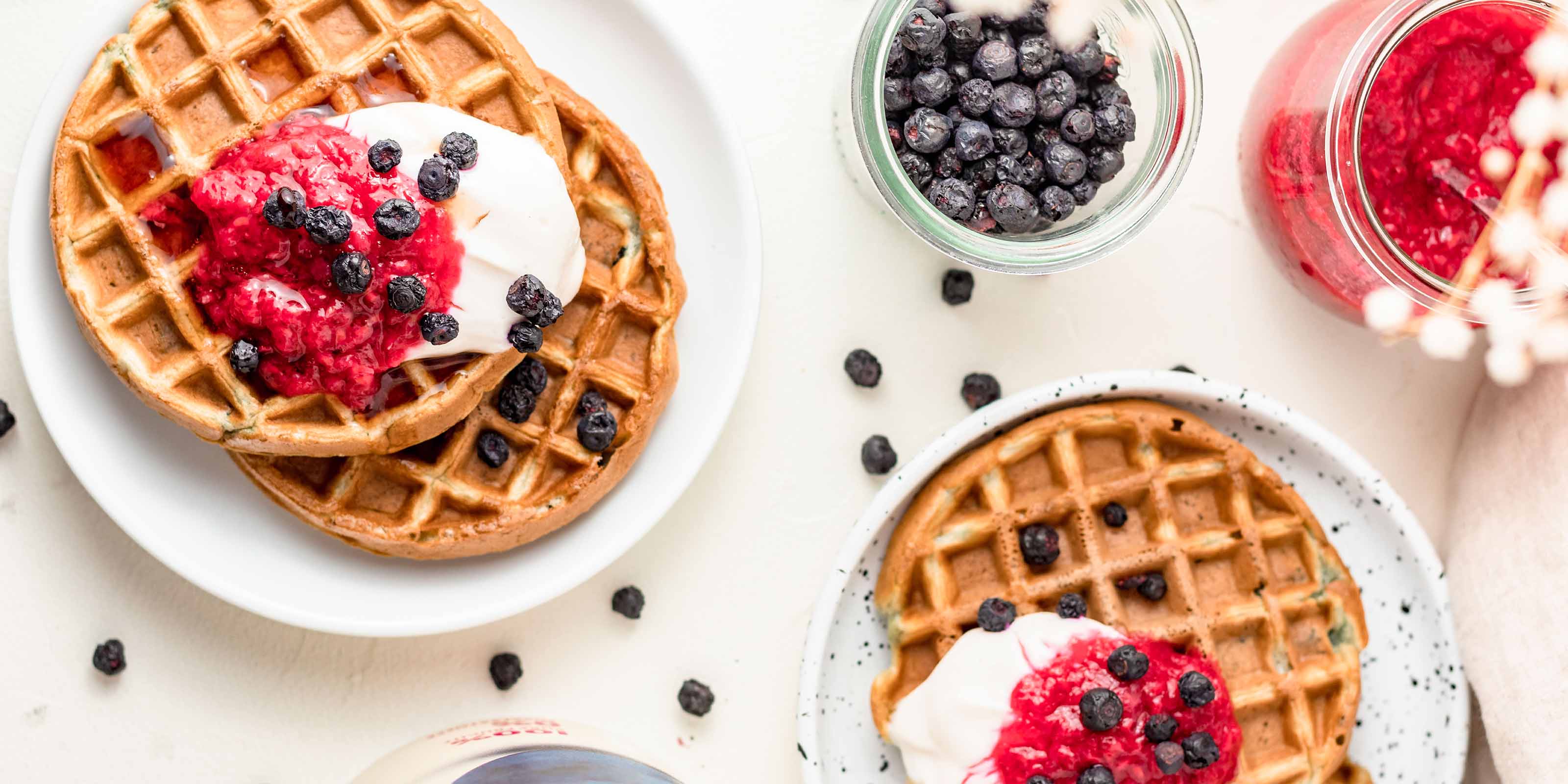 Belgische Waffeln mit puerierten buah Himbeeren und buah Blaubeeren als Topping auf einem Teller