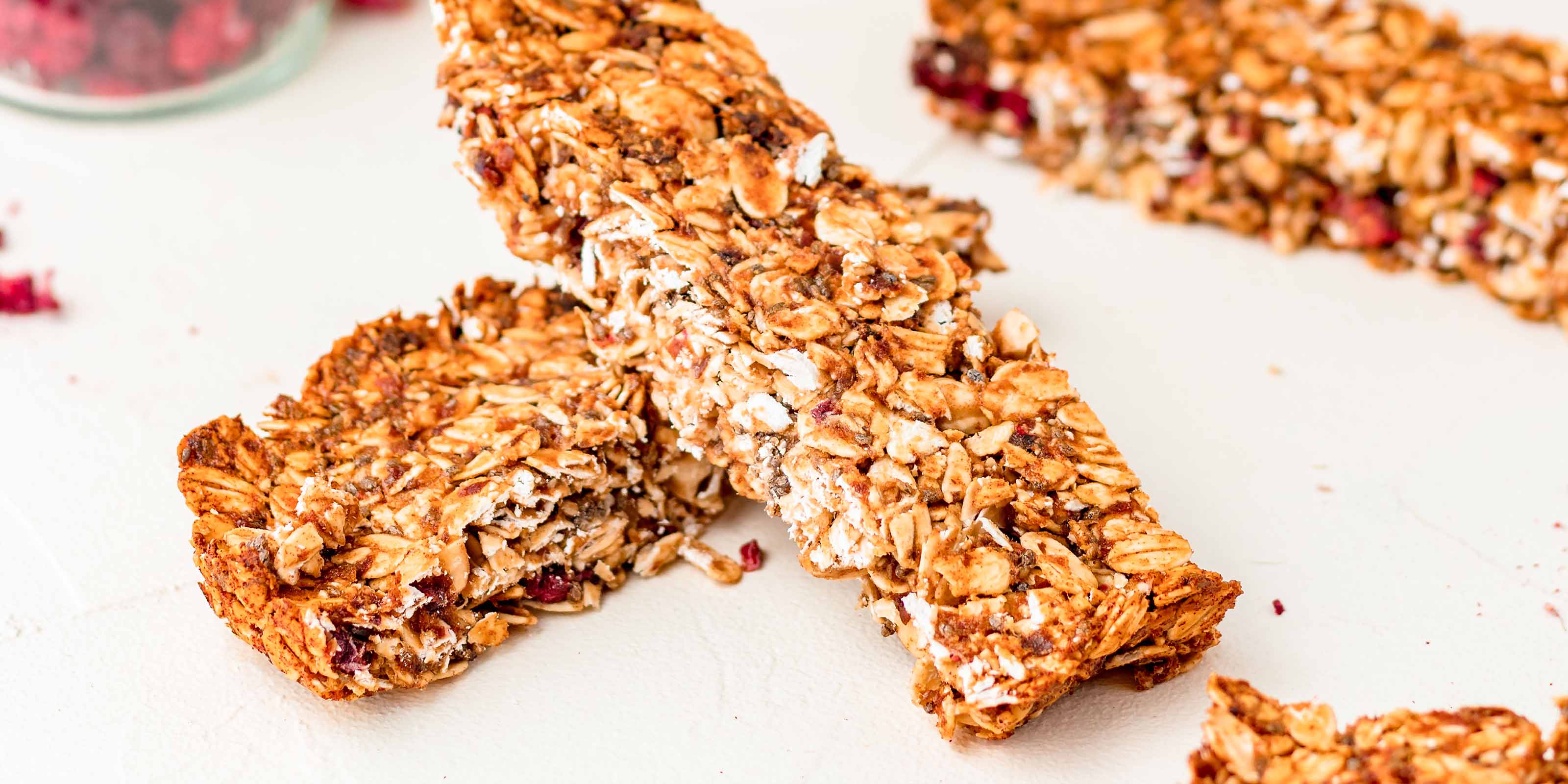 Zwei Muesliriegel mit buah Himbeeren liegen aufeinander auf einem Tisch