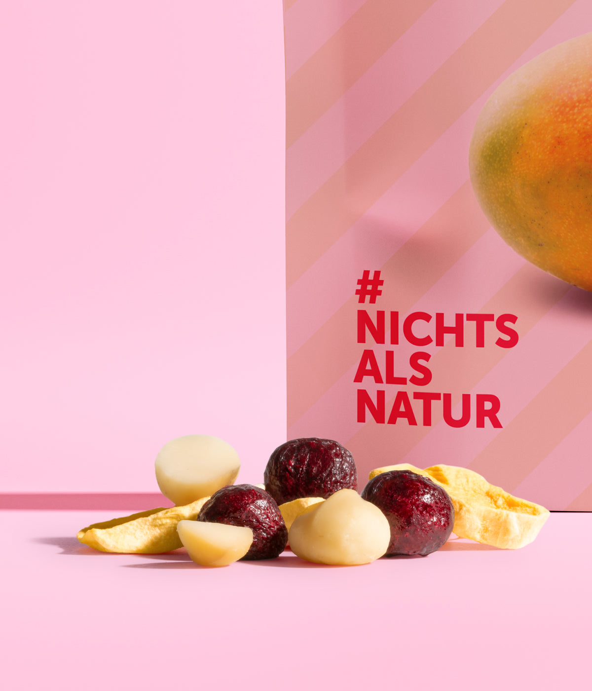 Neue Mischung aus buah gefriergetrockneter Sauerkirsche, Mango und frischer Macadamia Nuss in einem lecker aussehenden Haufen vor rosa Hintergrund